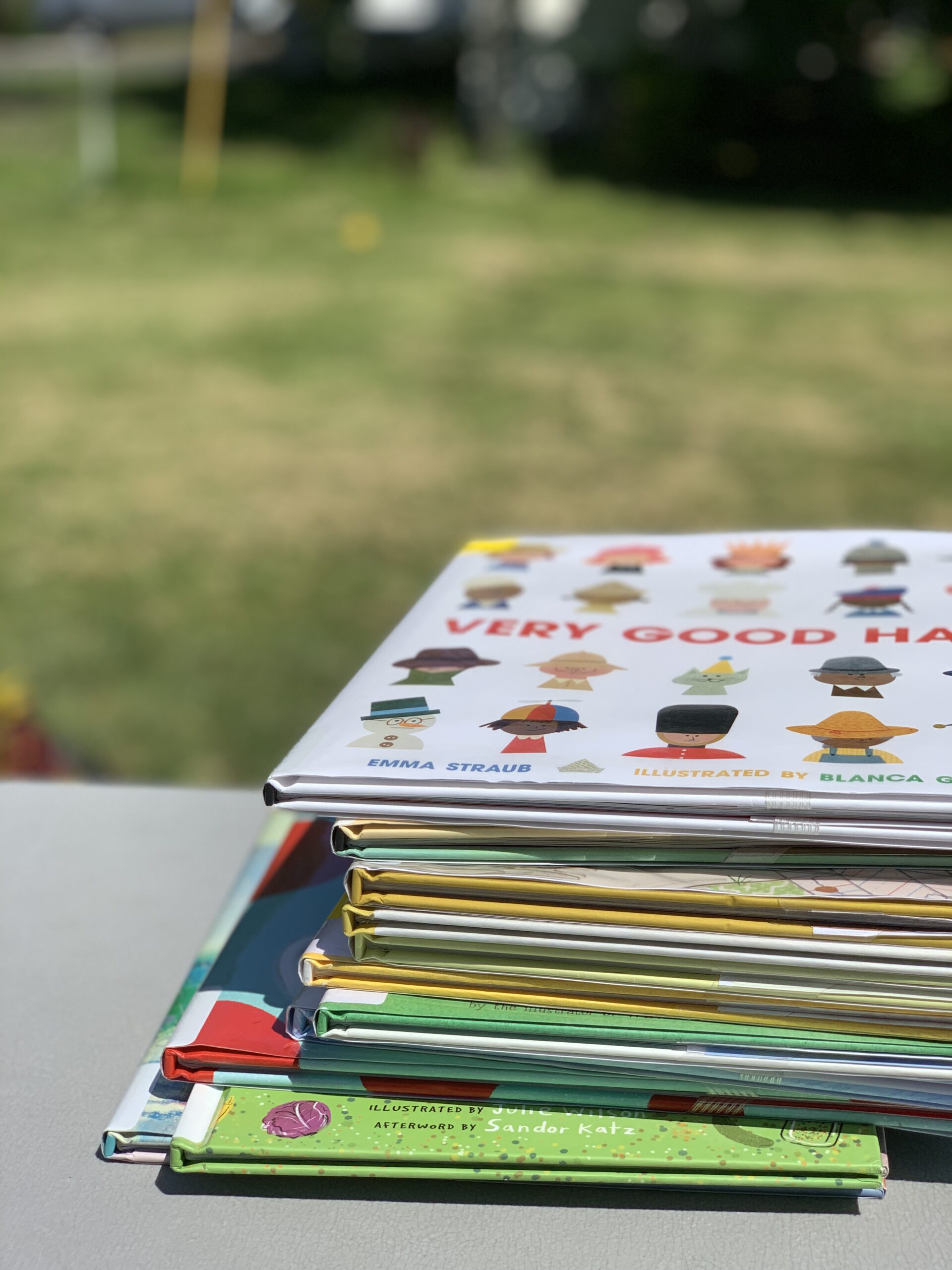 Stack of picture books on an outdoor table.