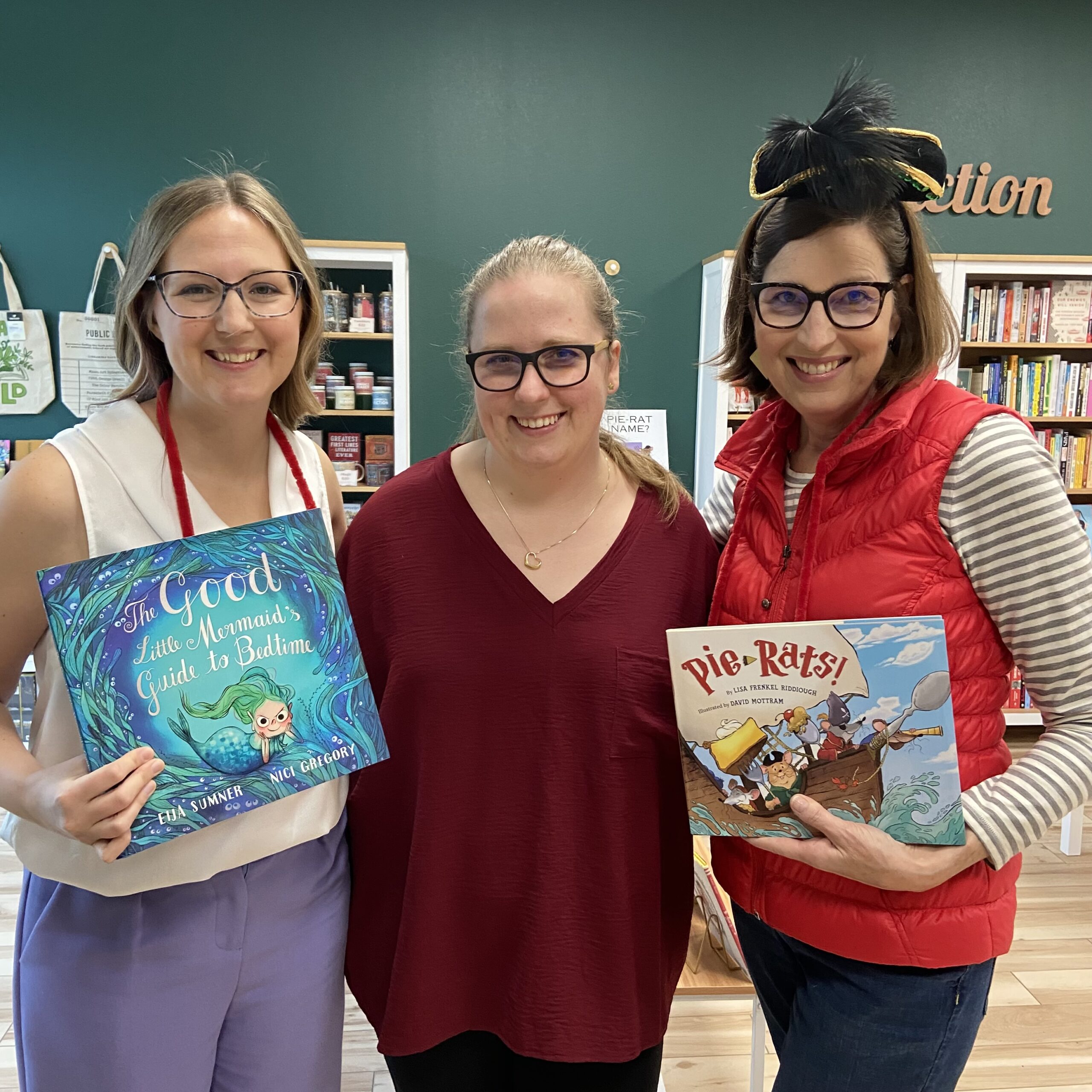 Three book friends all wearing glasses and holding picture books.