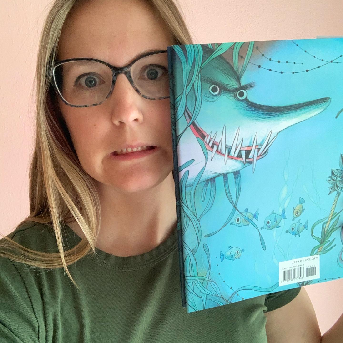 Eija staring and grimacing to match the shark on the back of her book.